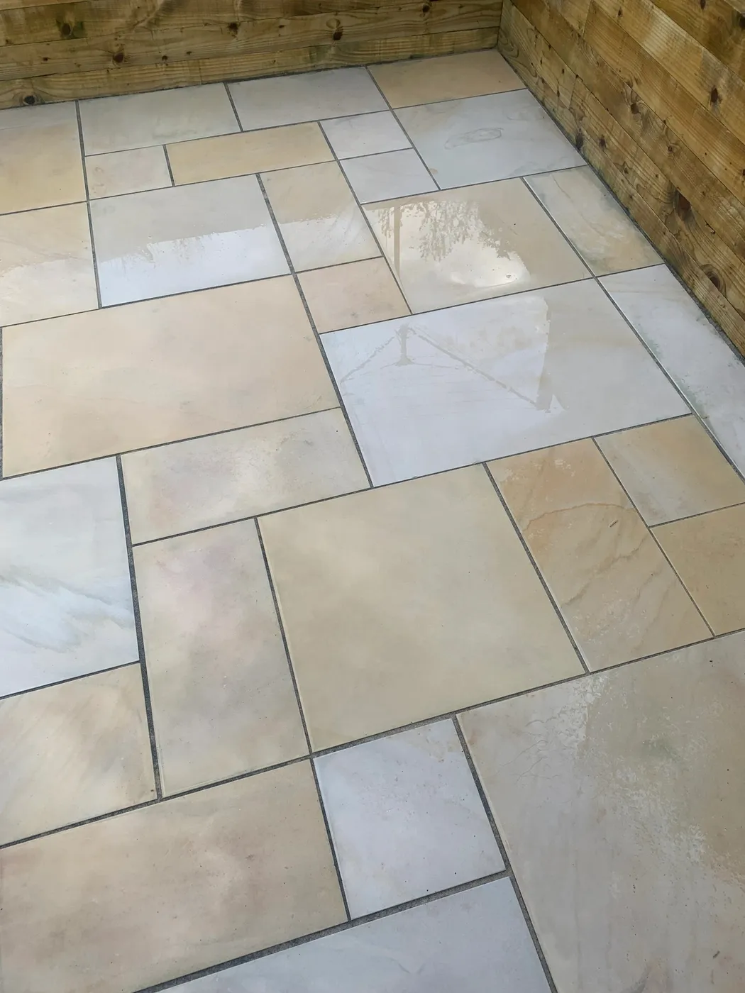 Clean Indian sandstone paving bordered by timber sleepers